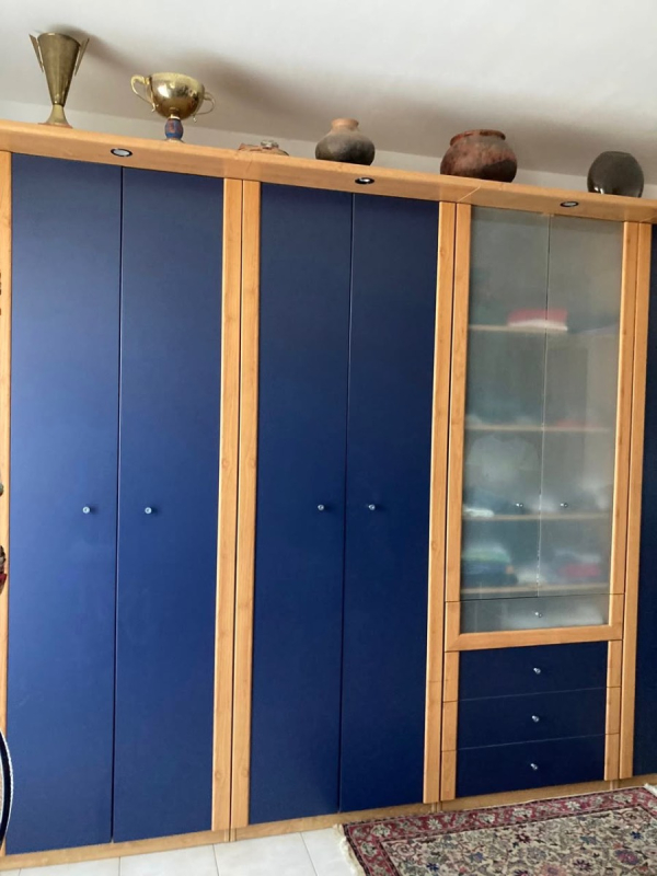 armadio blu IKEA in perfetto condizioni, dotato di luci, con quattro blocchi di ante, ripiani interni e cassetti esterni.