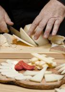 close-up-chef-cutting-cheese-wooden-board-min_original